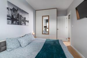 a bedroom with a large bed and a tv at Apartament GARNIZON in Gdańsk