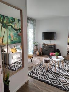 a living room with a couch and a tv at Lodge Du Petit Lion proche DISNEYLAND PARIS in Montévrain