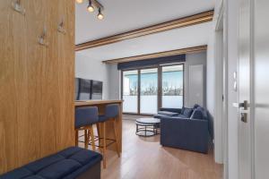 a living room with a blue couch and a bar at Apartament GARNIZON in Gdańsk