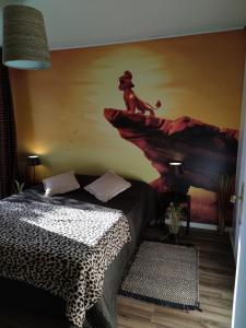 um quarto com uma cama com um macaco num penhasco em Lodge Du Petit Lion proche DISNEYLAND PARIS em Montévrain