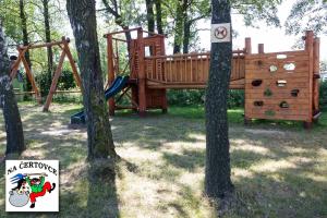 a playground in a park with a sign next to trees at Penzion na Čertovce in Dolní Orlice