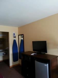 a room with a desk with a television and a mirror at Americas Best Value Inn Bryant in Bryant