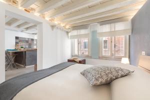 a bedroom with a white bed and two windows at Ramo del teatro Canal view in Venice
