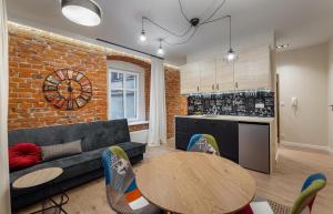 ein Wohnzimmer mit Sofa und Ziegelwand in der Unterkunft Coffee Apartments, MyWeek in Kłodzko