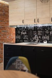eine Küche mit einer schwarzen Wand mit Schreibmaschine in der Unterkunft Coffee Apartments, MyWeek in Kłodzko