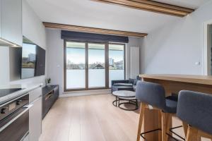 a kitchen and living room with a large window at Apartament GARNIZON in Gdańsk