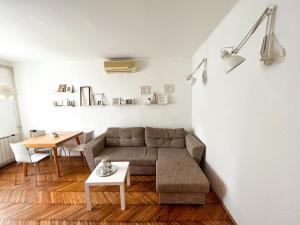 a living room with a couch and a table at Kopernik - parking available in Belgrade