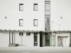 a person walking in front of a white building at livisit bergapartments in Stuttgart