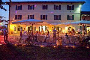 a group of people sitting at tables in front of a building at Agriturismo Rechsteiner in Ponte di Piave