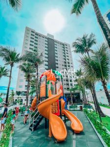 a playground at the beach with a slide at Apartamento em Resort - Premium in Salinópolis