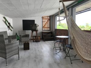 a room with a hammock and a table and chairs at affittacamere li di Giuan in Lauco