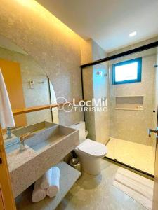 a bathroom with a sink and a toilet and a shower at Apartamento em Resort - Premium in Salinópolis