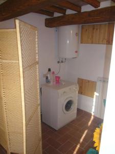 una sala de lavandería con lavadora en una habitación en casa Dany, en Bagni di Lucca