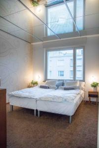 a bedroom with a large bed with a large window at Iso perheasunto keskustassa, Särkänniemen lähellä in Tampere