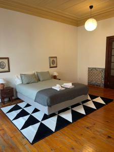 a bedroom with a bed with a black and white rug at Azulejos Cais Sodré B&B in Lisbon