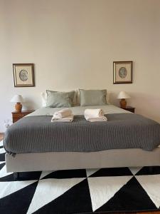a bedroom with a large bed with two towels on it at Azulejos Cais Sodré B&B in Lisbon