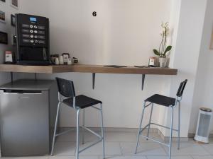 une cuisine avec un comptoir avec deux chaises et un four micro-ondes dans l'établissement B&B Viviani Potenza, à Potenza