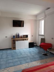 a living room with white walls and a red table at Villa Caribe affittacamere in Monterosso al Mare