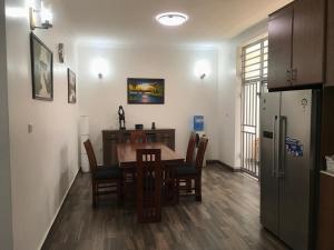 una cucina e una sala da pranzo con tavolo e frigorifero di Résidence DORVILIER 2. a Gisenyi