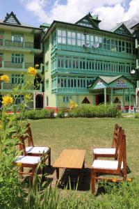 dos sillas y una mesa frente a un edificio en Hotel Mount Kailash, en Sāngla