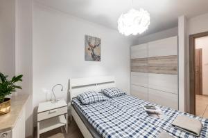 Posteľ alebo postele v izbe v ubytovaní Waw Apartamenty Manhattan
