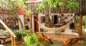 a patio with a hammock and a table and chairs at Nossa Casa Caraíva - A melhor localização da Vila in Caraíva