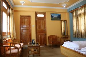 1 dormitorio con 1 cama, 1 silla y 1 mesa en Hotel Mount Kailash, en Sāngla