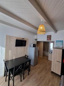 a dining room with a black table and a refrigerator at Villa du Lez in Prades-le-Lez