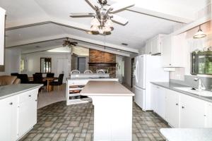 a kitchen with white cabinets and a living room at 05244 - 44 Pego Circle in Hot Springs Village
