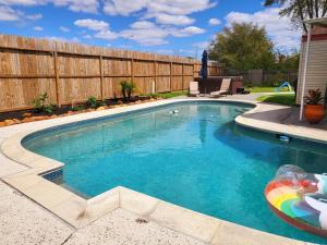 a swimming pool in a backyard with a wooden fence at 1976 HoustonGem Luminous Pool & HotTub sleeps11 in Houston