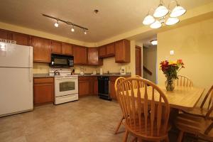 a kitchen with a white refrigerator and a table with chairs at Nautical Mile Resort in Wells