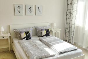 1 dormitorio blanco con 1 cama con 2 almohadas en Apartment E - feel good, en Leipzig