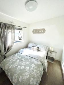 a bedroom with a bed and a window at Whiskey river chalet-Glan Gwna Holiday Park in Caernarfon