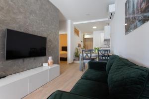 een woonkamer met een zwarte bank en een flatscreen-tv bij Apartment Laura Omiš in Omiš