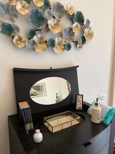 einen Waschtisch mit einem Spiegel an der Wand mit einem Spiegel in der Unterkunft Residenze Pessina in Neapel