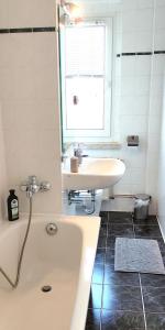 Un baño con bañera, lavabo y ventana. en Apartment E - feel good, en Leipzig 22 fotos más