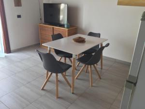 mesa y sillas en una habitación con TV en Apt71 Porto Antigo 2 en Santa Maria