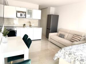 a kitchen and living room with a table and a couch at Apartment Vila ** in Stinica