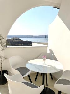 una mesa y sillas blancas en una habitación con ventana en Apartment Vila **, en Stinica