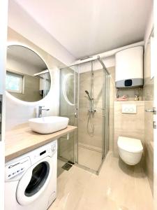 a bathroom with a sink and a washing machine at Apartment Vila ** in Stinica +27 photos