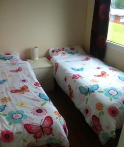 duas camas sentadas uma ao lado da outra num quarto em 9 Sea Valley em Clovelly