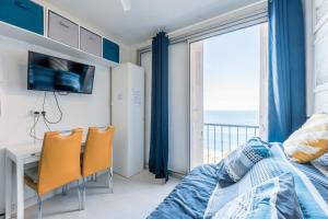 a bedroom with a bed and a desk with chairs at Studio "Les Roches blanches" - Vue mer & Vignes in Banyuls-sur-Mer