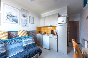 a living room with a couch and a kitchen at Studio "Les Roches blanches" - Vue mer & Vignes in Banyuls-sur-Mer