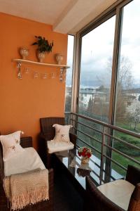 d'un balcon avec deux chaises, une table et des fenêtres. dans l'établissement Elegant Visoko, à Visoko