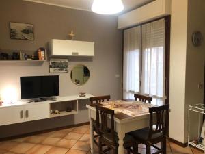 a dining room with a table with chairs and a television at Casa Willi in Fano