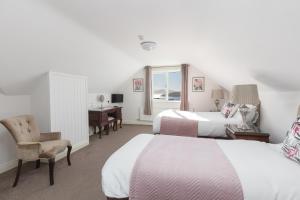 a hotel room with two beds and a desk at The Lighthouse in Dingle