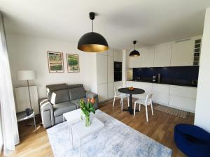 a living room with a couch and a table at EXIGEHOME-Appartement de standing en plein centre ville in Maisons-Laffitte