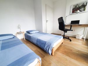 a bedroom with two beds and a desk and a chair at EXIGEHOME-Appartement de standing en plein centre ville in Maisons-Laffitte