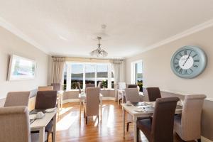 a dining room with tables and chairs and a clock at The Lighthouse in Dingle