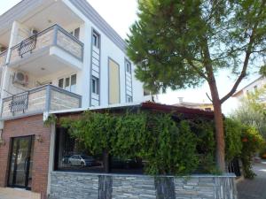 a white building with a tree in front of it at GÜNEŞ APART OTEL in Pamukkale